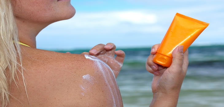 Rwoman applying sunscreen